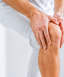 Person holding their knee representing joint support and mobility health